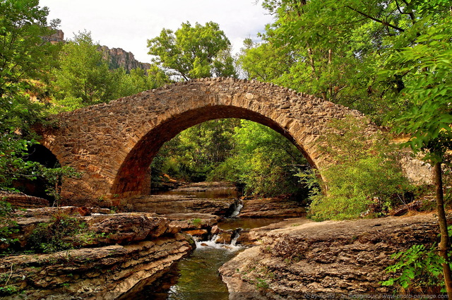 Le pont des six liards
Construit par les moines bénédictins au XIIÂ°siècle, ce pont de pierre reliait le Causse Méjean à  l'ancien prieuré de [i]St Martin des Ayres[/i]. Un taxe de péage de six liards était perà§ue à  chaque passage, d'oà¹ le nom que ce pont a conservé au
fil des siècles.
Au premier plan : la rivière de la Jonte
Ayres / Meyrueis (Lozère). 
Mots-clés: categ_pont meyrueis lozere cevennes monument riviere jonte categ_campagne massif_central les_plus_belles_images_de_ville