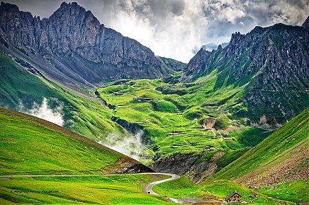 Une route sinueuse qui monte au loin jusqu'au Col de la ParÃ©

PhotographiÃ©e depuis le col du Galibier.
Au premier plan, la route qui descend du Col du Galibier.
Massifs des Arves et des Cerces