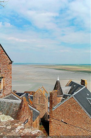 Les-toits-des-maisons-anciennes-sur-le-Mont-Saint-Michel---la-baie-en-arriere-plan.jpg